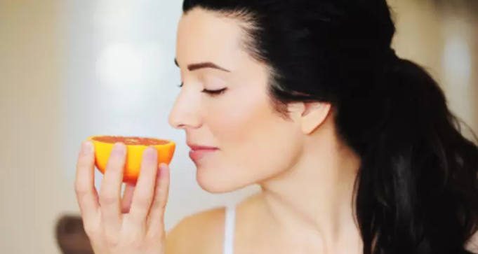 Woman Smelling Orange